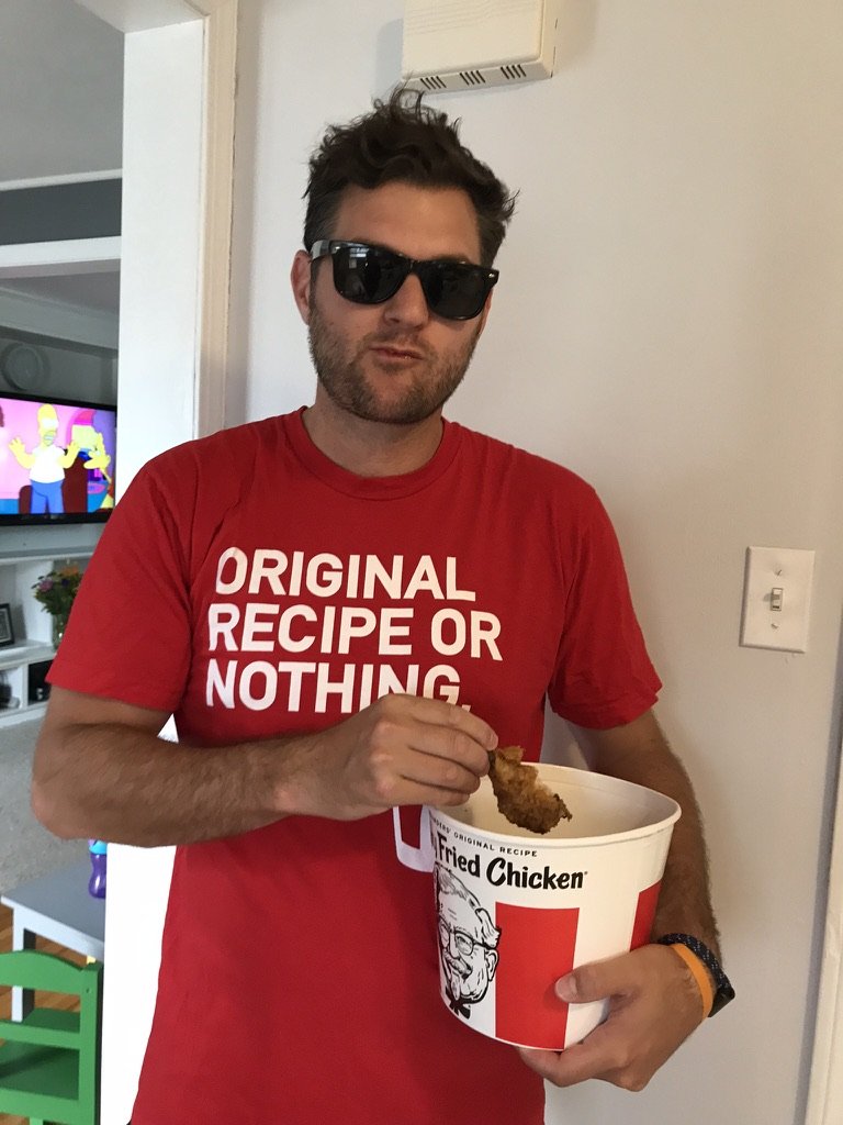 The founder in an Original Recipe or Nothing tee, eating from a bucket of fried chicken