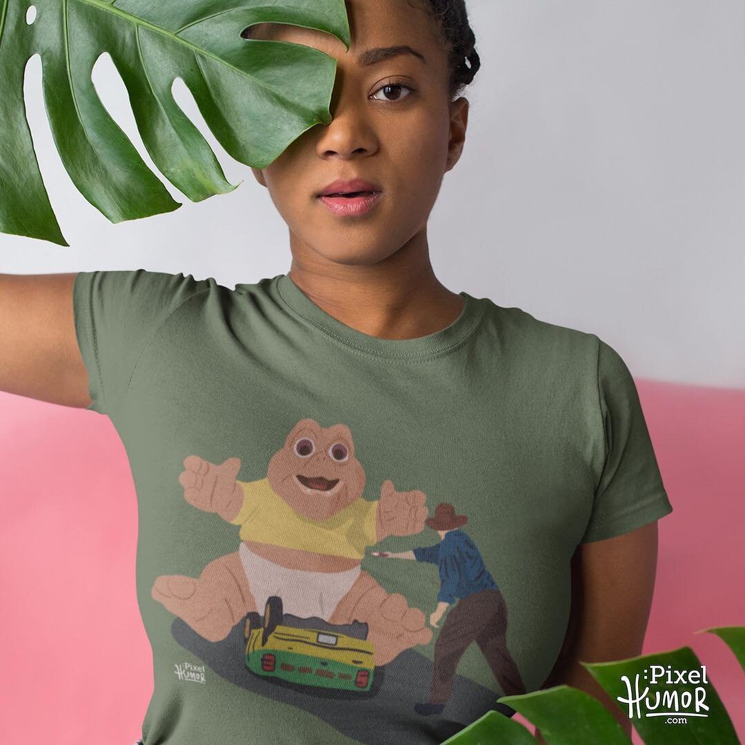 T-shirt with a giant baby dinosaur looming over an overturned jeep
